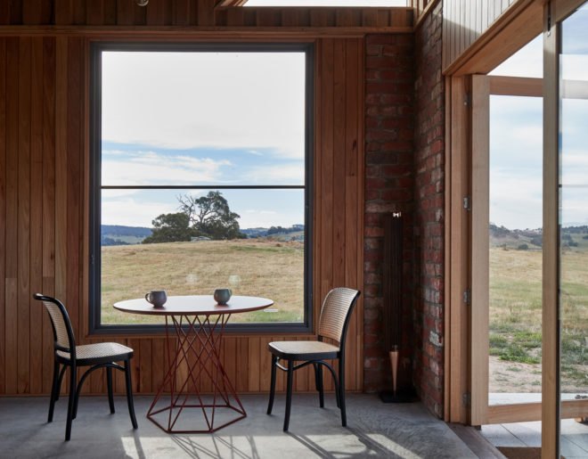 two dining chairs and small dining table near a large window