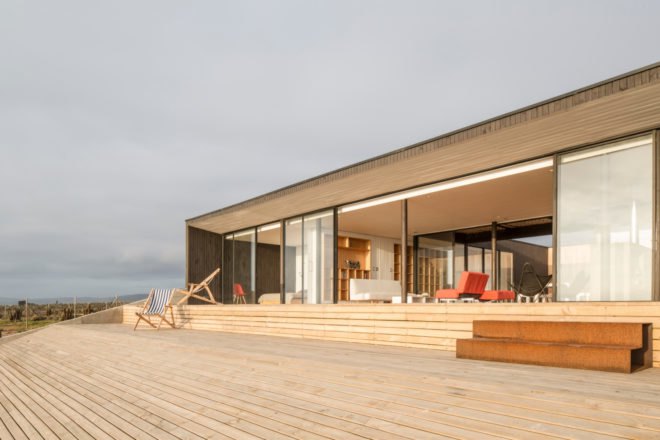 living area with open glass doors to large outdoor deck