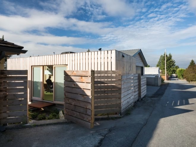 view of white shipping container surrounded by wood fence