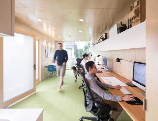 architects working at long wood desk against timber wall