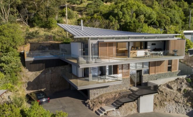stone home with sloped roof built into green hillside