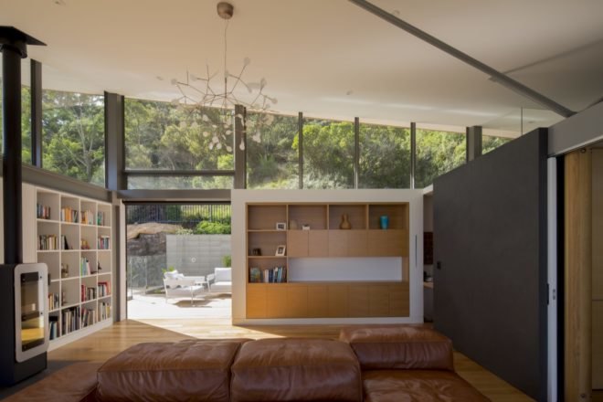 living room with tan leather couch and white and light wood built-in shelves