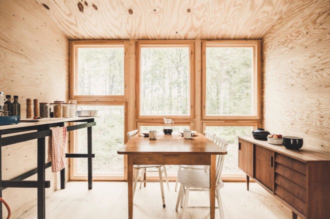wood dining table in front of large windows