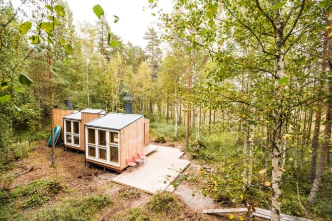 aerial shot of wooden cabin surrounded by forest