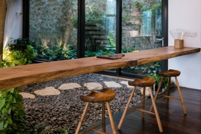 wooden bar stools pulled up to a long wooden floating shelf