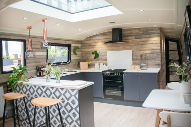kitchen with wood walls, gray cabinets, white counters, and potted plants