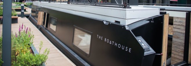 Black canal boat with rooftop deck