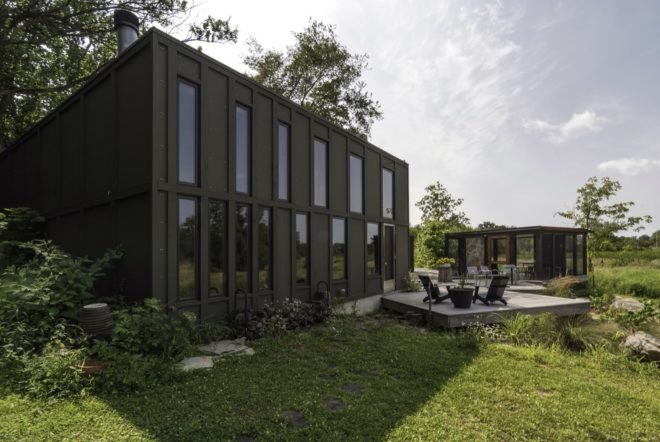 black cube home with gray patio