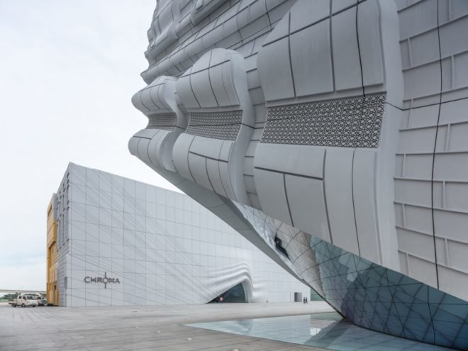 white building with warped corner and entrance with mirrored tiles