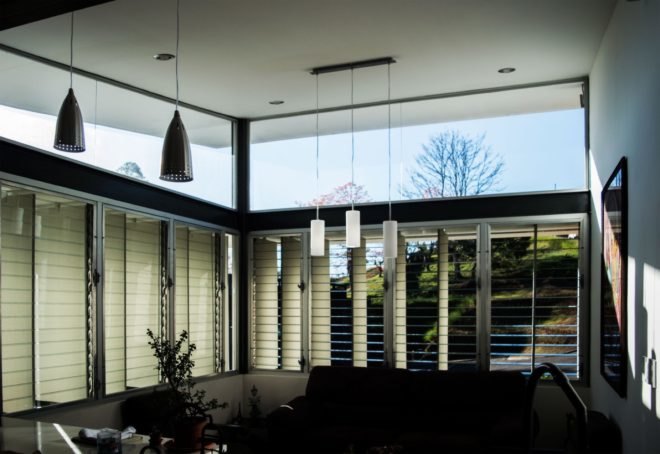 living space with hanging pendant lamps and windows slightly covered by solar shades
