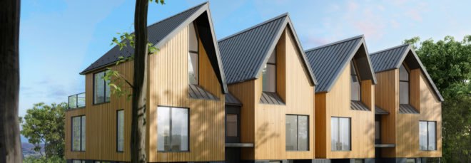 cropped close up of four connected structures with light wood exterior and gabled roofs