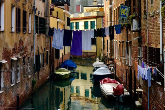 blue clothes hanging on a line above a canal