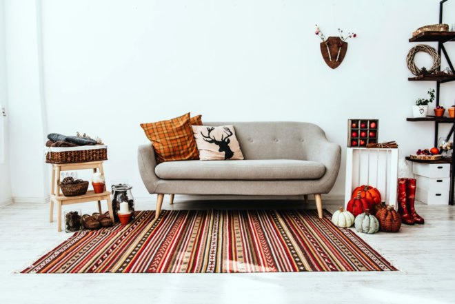 living room with gray couch and orange and red decorations