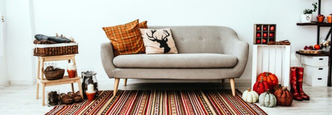 cropped close-up of living room with gray couch and orange and red decorations
