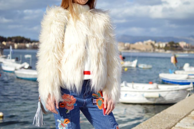 woman near water wearing white fur coat