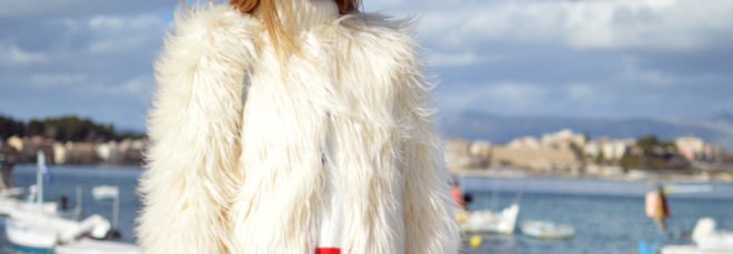 cropped close-up of woman near water wearing white fur coat