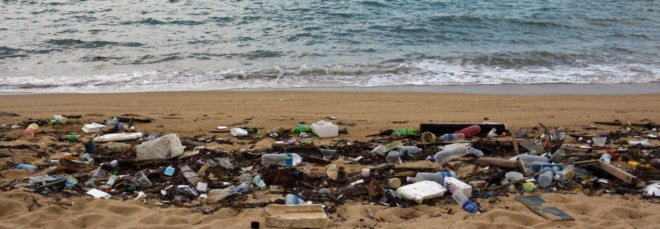 cropped close-up of heaps of trash on a beach
