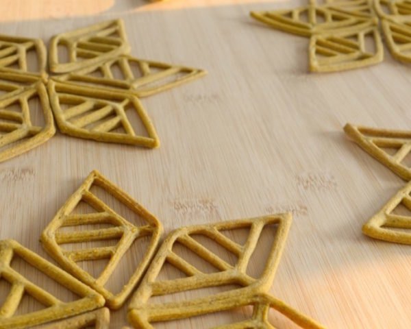 cropped close-up of tan snowflake-shaped snacks on a wood board