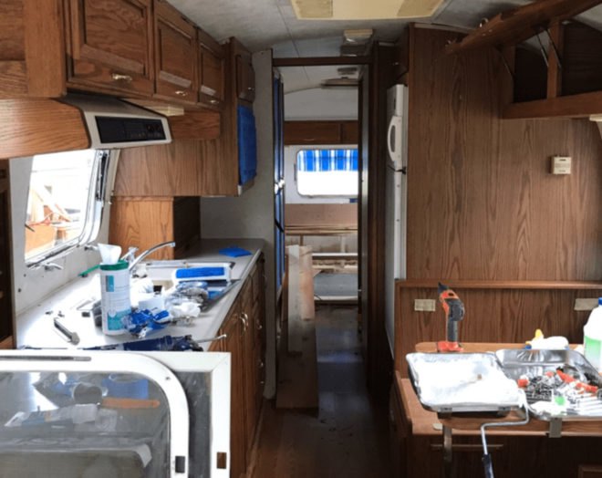 Before photo of a dark wood-lined Airstream interior