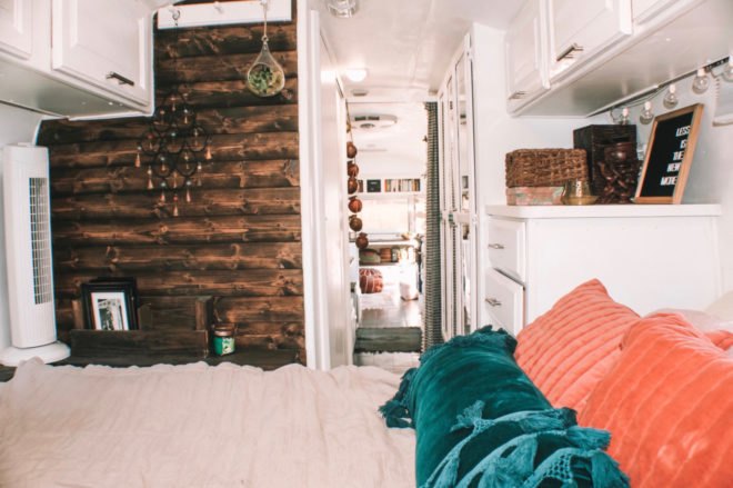 a bed with green and orange pillows