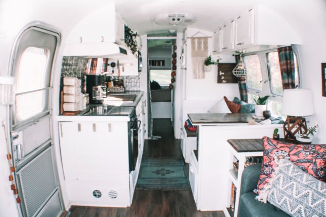 white interior living space with small kitchen and dining area