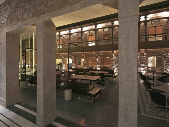 new restaurant with restored stone walls and open-air dining space with marbled floors