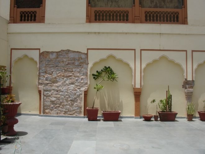 stone wall revealed under plastered walls