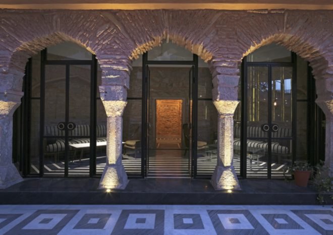 black-framed glass windows and doors in a restored stone building