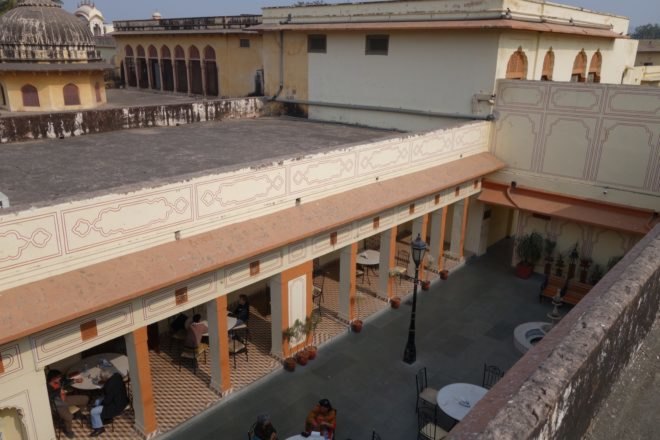 before image of plastered buildings with open-air dining space