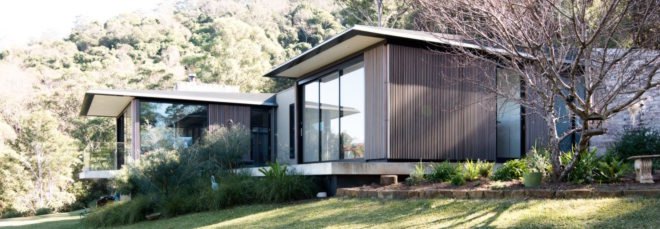 cropped close-up of timber-clad home with large glass windows