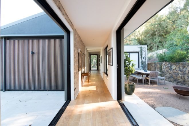 hallway with large sliding glass walls and light wood floors
