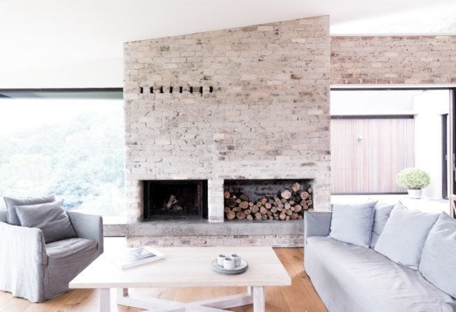 bright living room with recycled brick wall and gray couch and chair