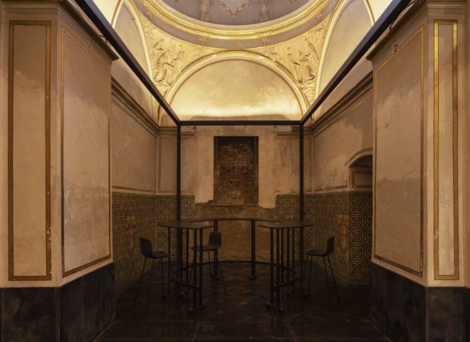 dimly lit space with gold walls and round table with chairs