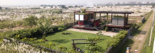 aerial view of red shipping containers topped with a green roof