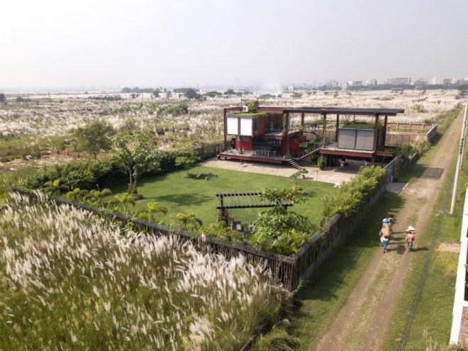 aerial view of red shipping containers topped with a green roof