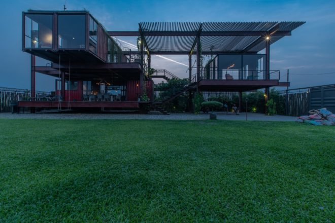 stacked red shipping container home at night