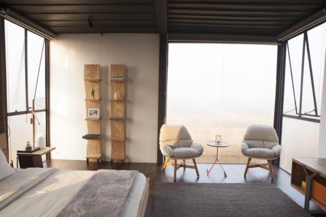 white bedroom with white chairs and white bed