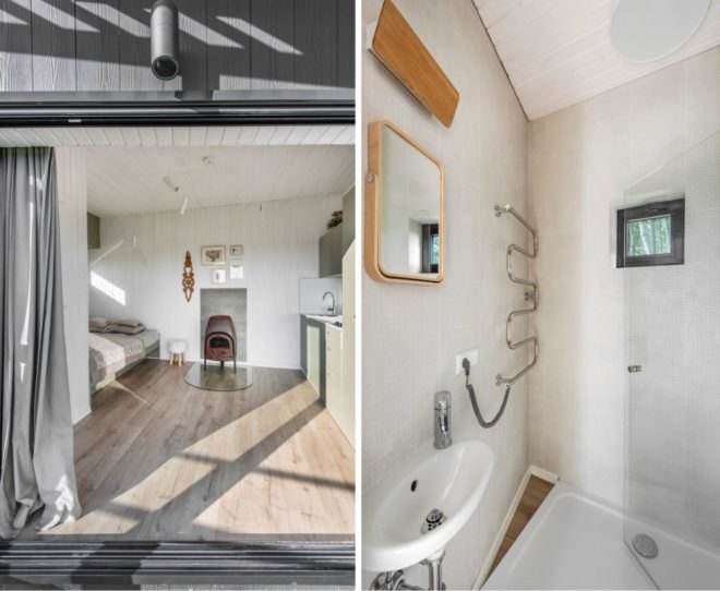 On the left, white room with tan bed and wood-burning stove. On the right, white bathroom with small wood-framed mirror.
