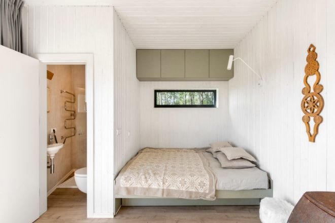 a bedroom with white walls and tan bedding