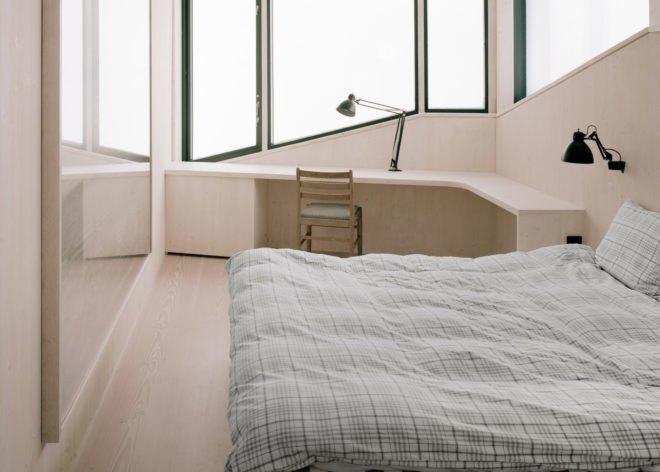 a bedroom with a bed and large windows