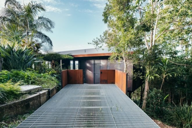 walkway to cabin with weathered steel exterior