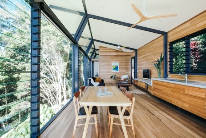 cabin with glass and timber walls and a wood dining table