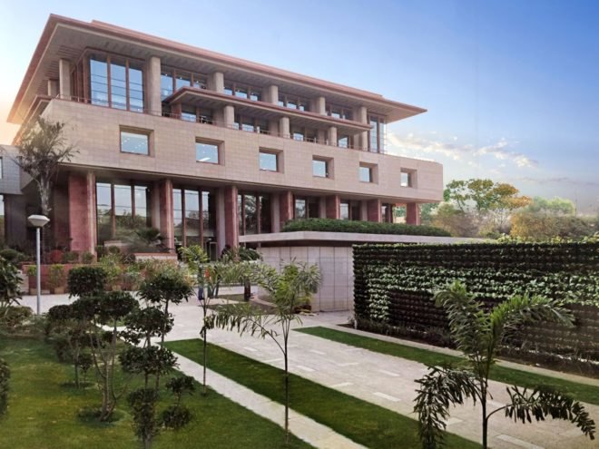 green space in front of tan brick building