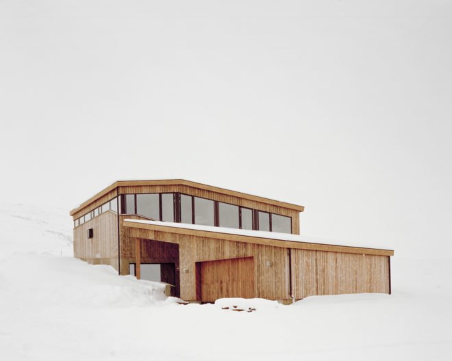 a light wood cabin on snowy hill