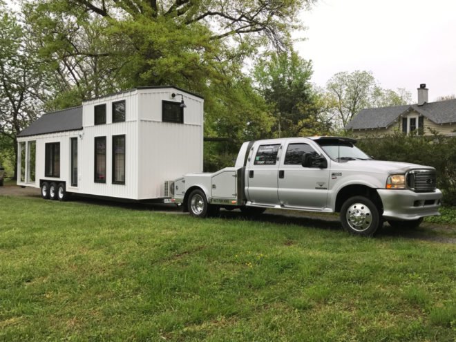tiny home on wheels being towed by a truck