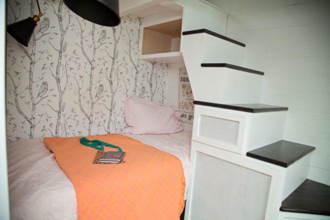 small pink bed partially underneath staircase