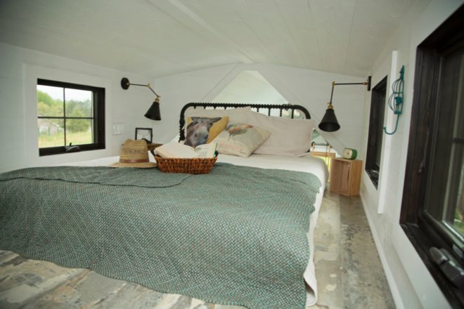 bed with gray comforter in tiny room