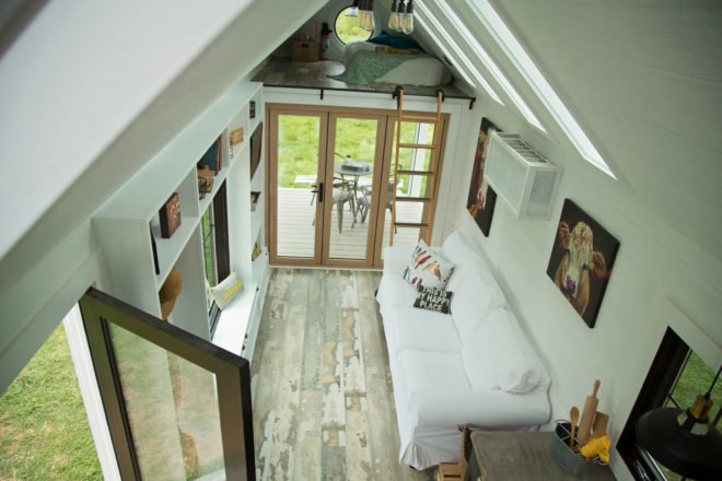 aerial view of white living space with white couch and cow artwork on the walls