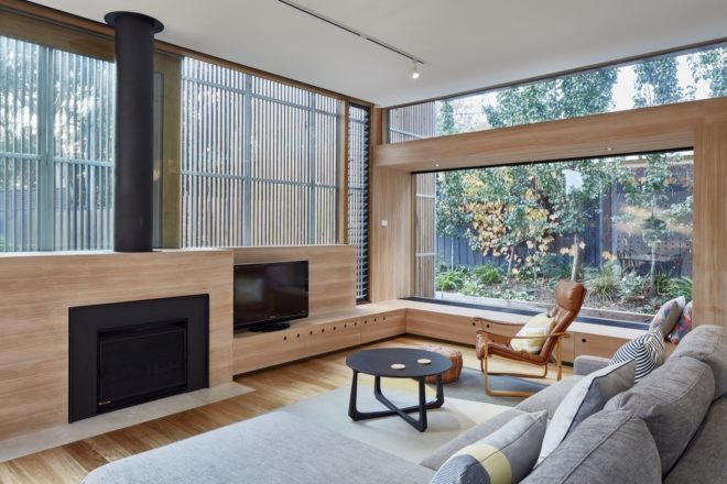 gray sectional sofa facing a fireplace in a timber-lined living room