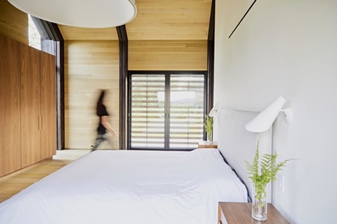 bedroom with timber walls and floors and white bedding